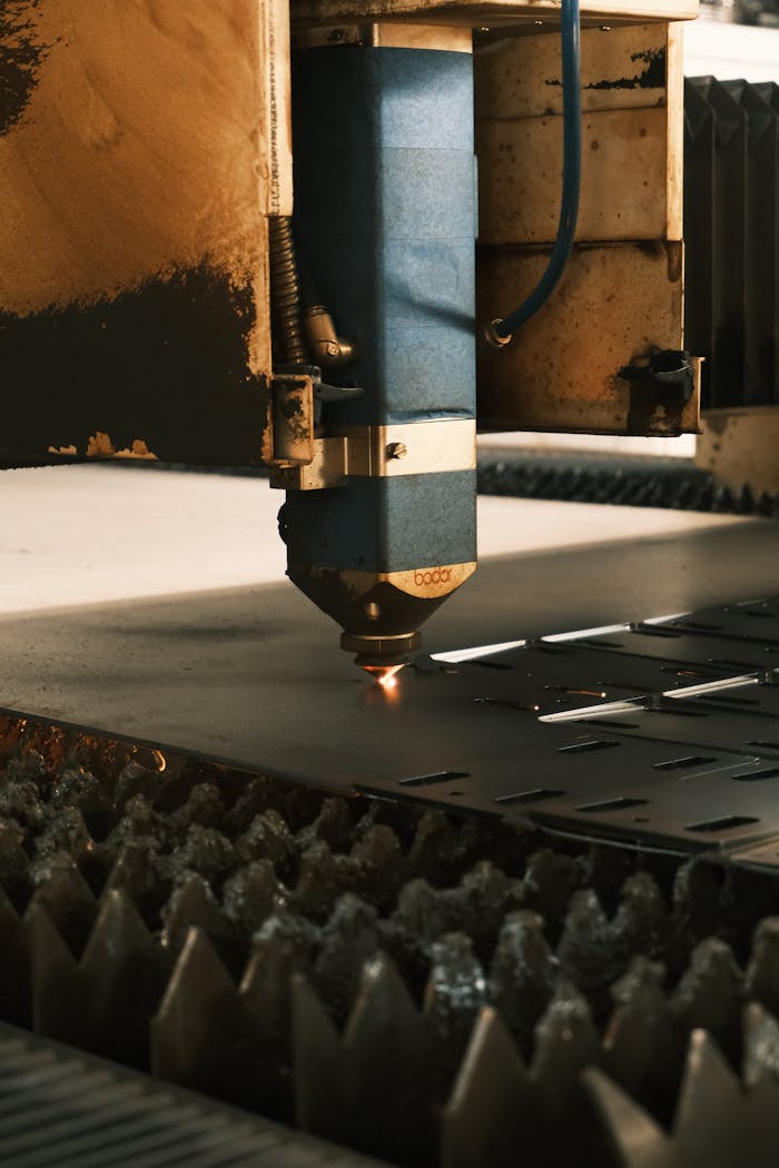 Close-up of a laser cutter in an industrial setting performing precise metal cutting.