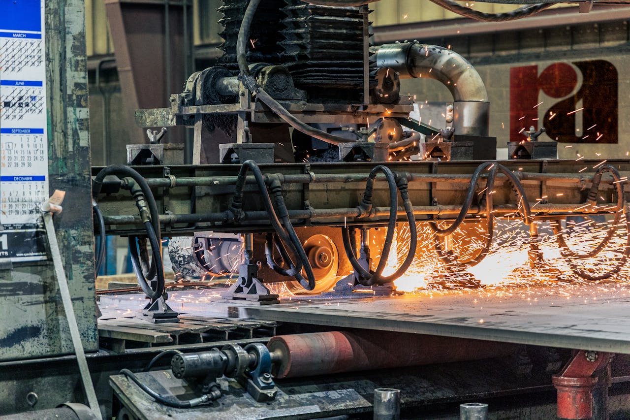 Detailed view of industrial machinery cutting metal, showcasing sparks and heat.