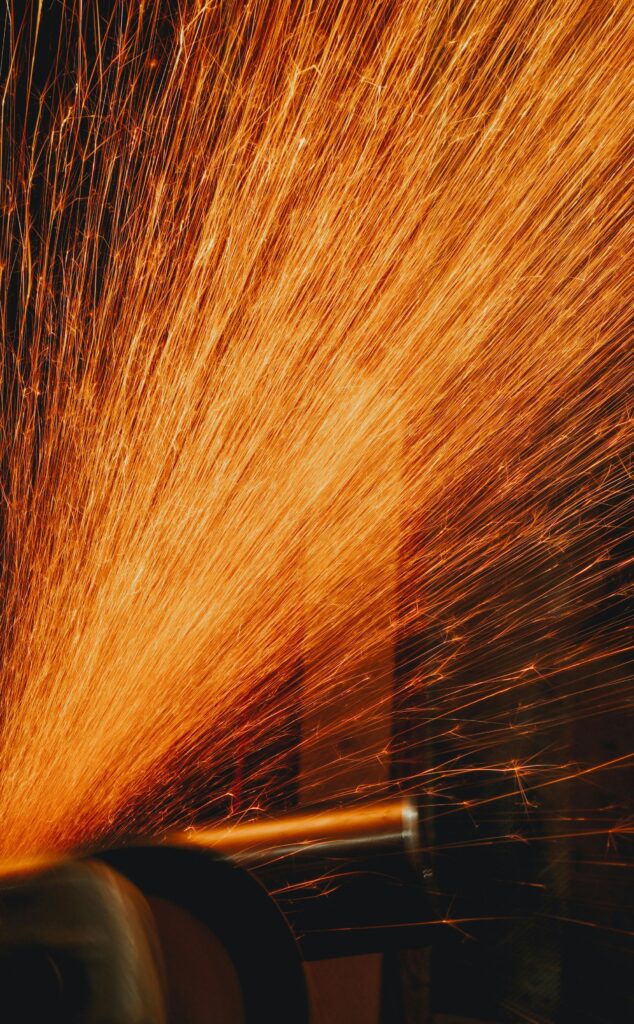 Close-up of grinding sparks flying in an industrial setting, capturing dynamic motion and heat.